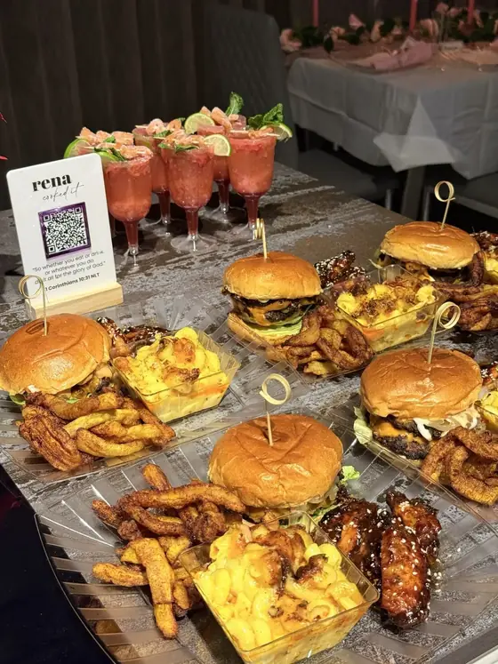 Burgers, loaded fries and mocktails laid out for an event