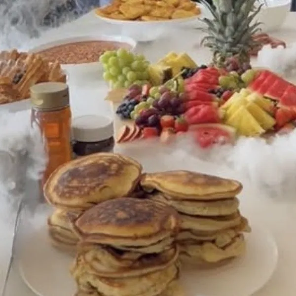 Brunch table with pancakes, fruit and dry ice
