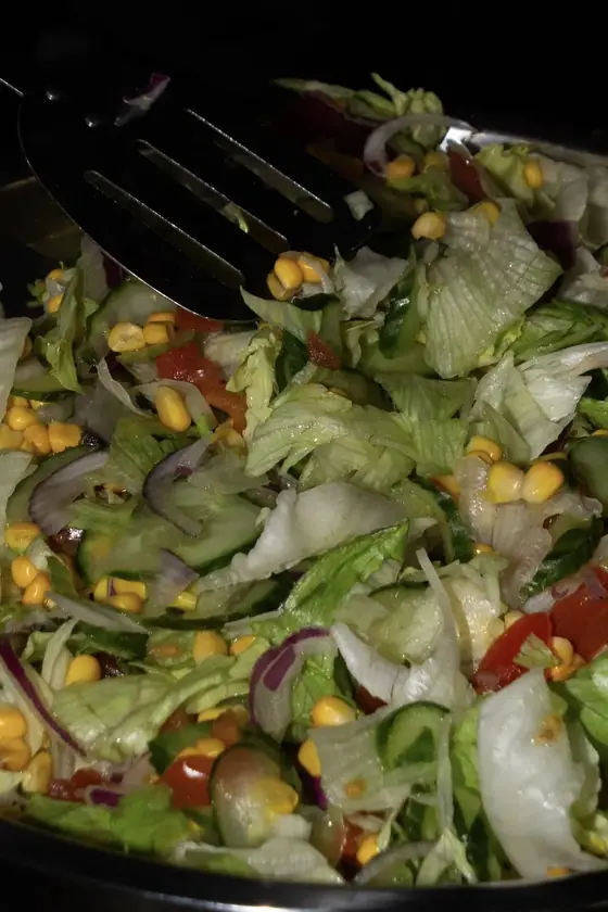 A big bowl of fresh salad with sweetcorn and red onion