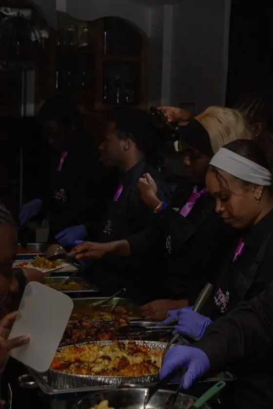 The team serving guests along a hot buffet line