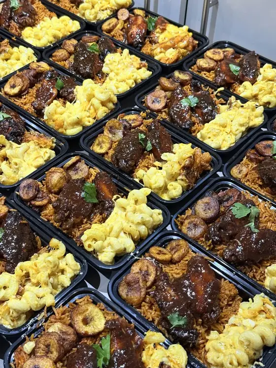 Rows of meal boxes with mac and cheese, chicken and plantain